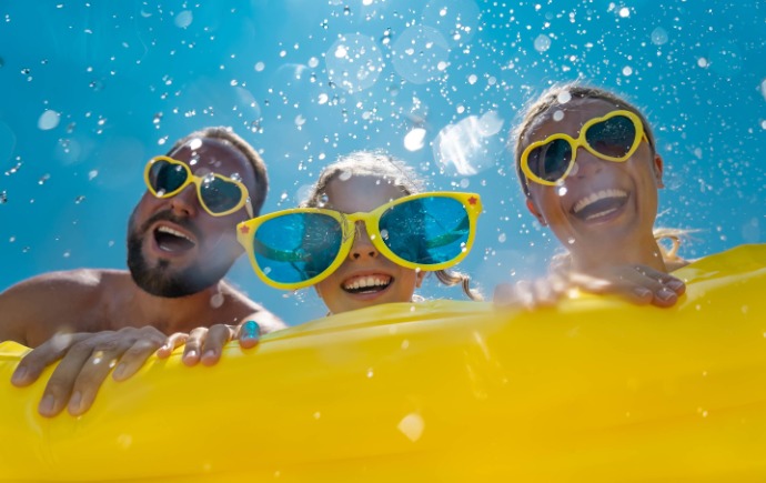 three people sunglasses on float in pool